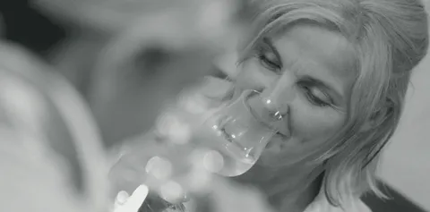 Eine Frau probiert ein Glas Weißwein